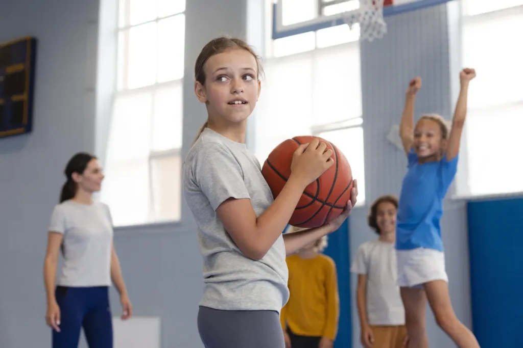Děti s basketbalovým míčem v tělocvičně