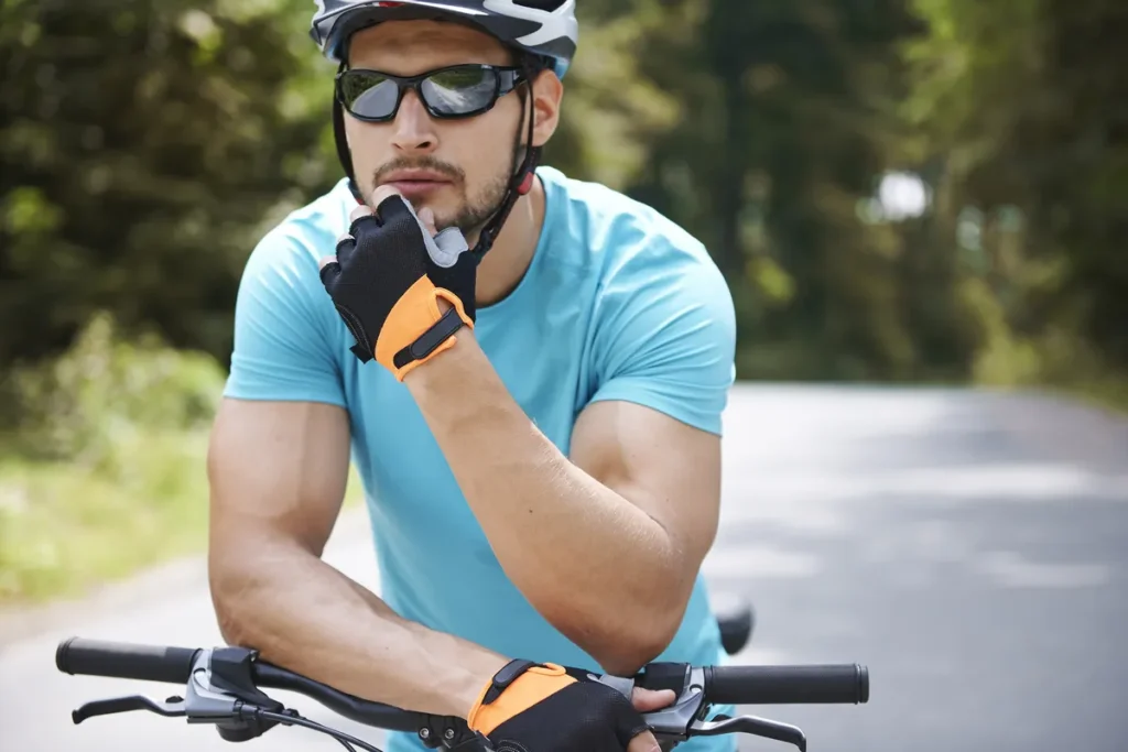 Cyklista ve sportovních brýlích a helmě na kole
